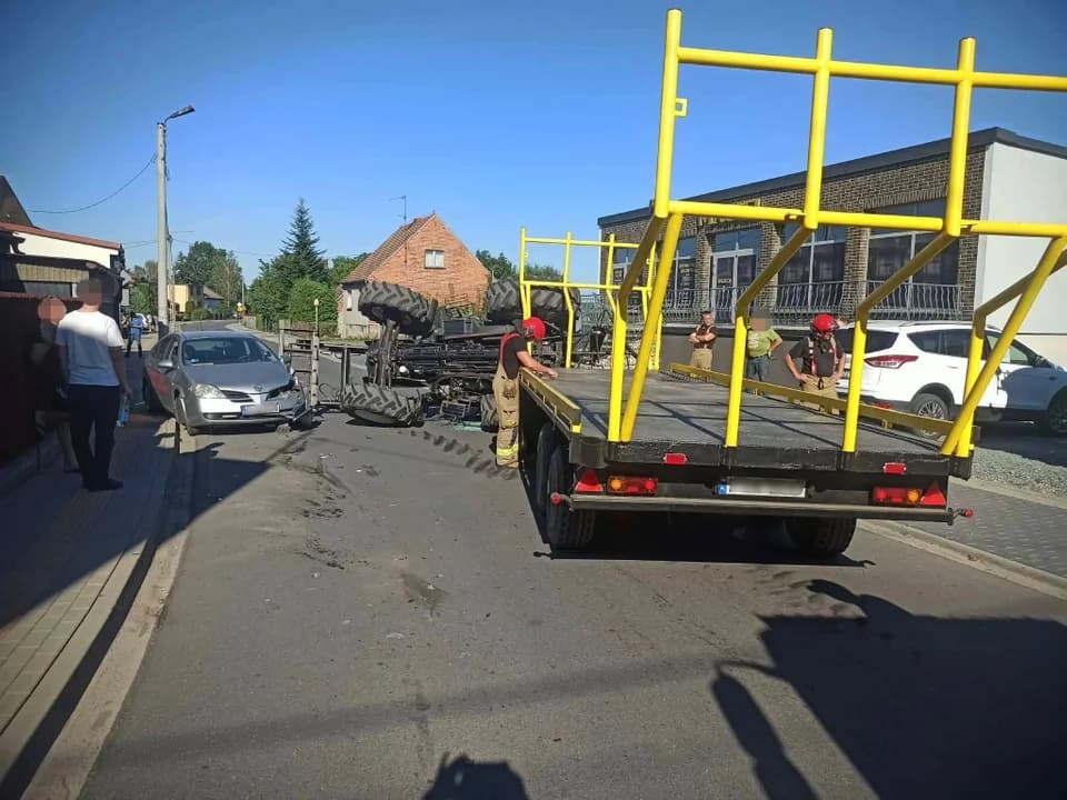 Ciągnik rolniczy przewrócił się na bok i uderzył ładowaczem czołowym w samochód osobowy.